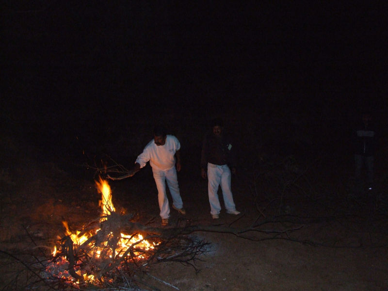 Babu tends the bonfire at Camp Tinker